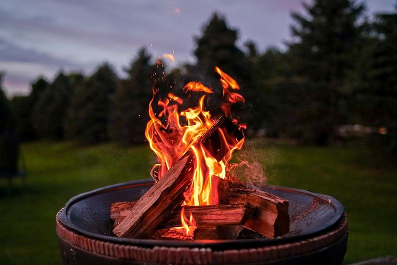A firepit with logs and an orange fire burning away