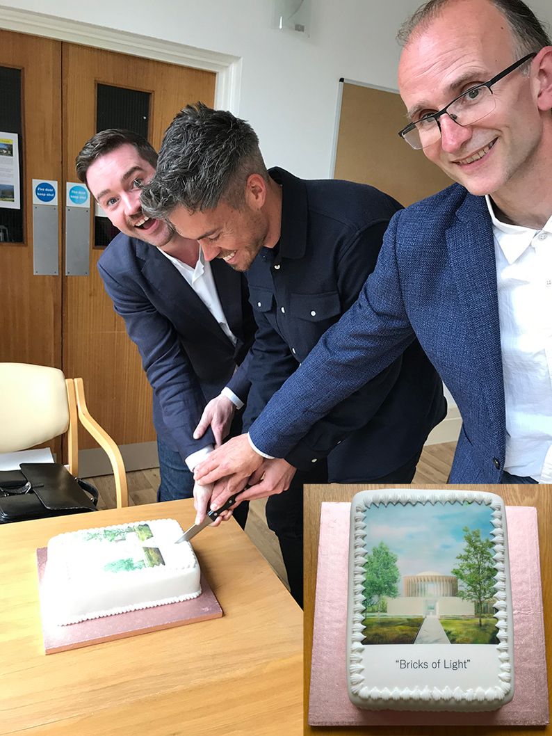 Three people cutting cake together
